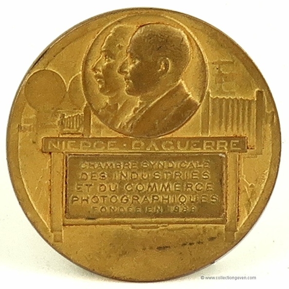 Médaille en bronze de la Chambre syndicale des industries et du commerce photographiques.
Marque : ???Fabricant : ???
Publicité : -
Pays : France
Date de début : 9999
Dimensions : Ø = 50 mm Poids : 51 g
Code EAN13 : -
Recto : « Niépce - Daguerre » gravé sur la médaille.
Portraits de Niépce et Daguerre dans un cercle.
À l'arrière plan sont représentés une chambre sur pied, un folding, un projecteur de cinéma et une presse.
Dans un rectangle, il est gravé « Chambre syndicale des industries et du commerce photographiques - Fondée en 1889 ».
Verso : « François Brossard ».
Tranche : « bronze », poinçon en triangle à identifier.
Commentaires : Médaille en bronze du graveur Grun.
Liens web : -
N° inventaire : GAD1529_01
GAD1529_01.jpg
