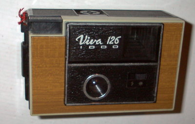 APP0574a
?, f11/40
rotatif, 2 vit.
-
Nom: Viva 126 1000 (1)
Marque: FEX; fabricant: Indo; publicité: -
Pays: France
Date: début: ?1978; fin: ?1979
Type: (CFFG)
Dimensions: 120x75x55mm; poids: 200
Matière: plastique; Couleur: noir/bois
Surface sensible: film 126; format: 28x28mm
Objectif: nom: ?; fabricant:?; ouv./focale: f11/40; fixation : fixe
Diaphragme: type: fixe; ouvertures: f11
Obturateur: nom: rotatif; fabricant: ?; vitesses: 2 vit.; pose: -
Retardateur: -; Armement: -
Compte-vues: fenêtre; Protection 2 expos: -
Synchro flash: flash-cube; flash intégré: -
Posemètre: type: -; plage: -; automatisme: manuel
Mise au point: type: fixe; mini: ?; télémètre: -
Décentrement vert.: -; hor.: -; bascule avant: -; arrière: -
Viseur: simple; Porte-accessoire: flash cube; Niveau: -
Mode d'emploi: -
Commentaires:
sans porte filtre; sérigraphie sur vitre
Appareil présenté
N° de série: -
N° objectif: -; N° obturateur: -
Accessoires: -; sac: -
APP0574a.jpg