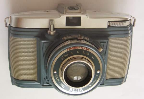 APP1726
Achromat, f8
central, 1/50s-1/100s
-
Nom: Bella (46)
Marque: KURBI; fabricant: -; publicité: -
Pays: Allemagne
Date: début: -1955; fin: -1958
Type: (CFFN)
Dimensions: 122x82x70mmmm; poids: 320g
Matière: métal; Couleur: gris bleu
Surface sensible: film 127; format: 4x6cm
Objectif: nom: Achromat; fabricant:?; ouv./focale: f8; fixation : fixe
Diaphragme: type: rotatif; ouvertures: f8,f11
Obturateur: nom: central; fabricant: ?; vitesses: 1/50s-1/100s; pose: B
Retardateur: -; Armement: -
Compte-vues: fenêtre; Protection 2 expos: -
Synchro flash: X; flash intégré: -
Posemètre: type: -; plage: -; automatisme: manuel
Mise au point: type: frontale; mini: 1m; télémètre: -
Décentrement vert.: -; hor.: -; bascule avant: -; arrière: -
Viseur: galilee; Porte-accessoire: sabot; Niveau: -
Mode d'emploi: -
Commentaires:
voir APP0357
Idem Bella 46, Bella D
http://www.kameraschaetze.de/1Kamera/Bilora/Bella_3c.html
Appareil présenté
N° de série: -
N° objectif: -; N° obturateur: -
Accessoires: -; sac: tout prêt, plastique, gris clair, déchiré
APP1726.jpg